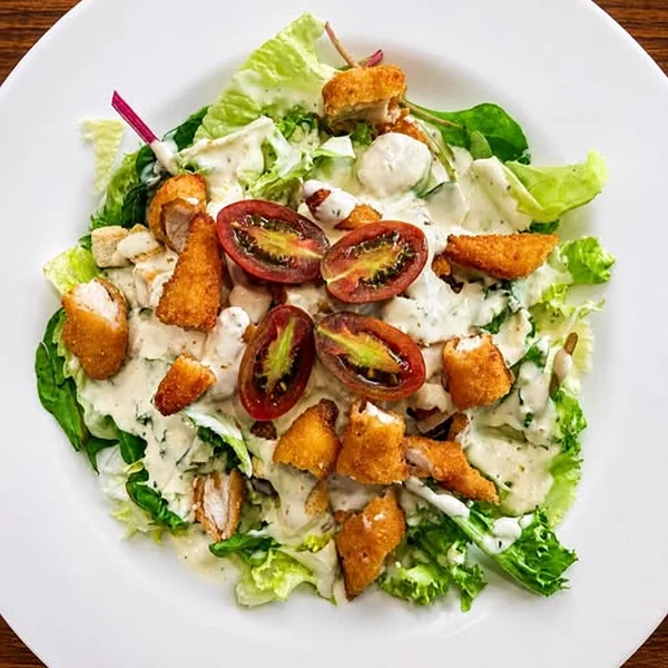 Ensalada César con pollo crujiente y tomate cherry