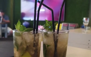 Mojitos en la barra con la pantalla de fútbol al fondo